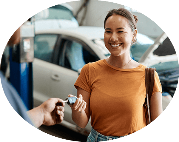 Customer handing key to automotive technician